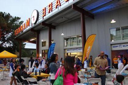 菠菜网lol正规平台 community members sit outside San Pedro Square Market for an event.